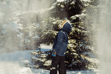 Obraz premium cute russian boy catching snowflakes with his tongue in park. Image with selective focus