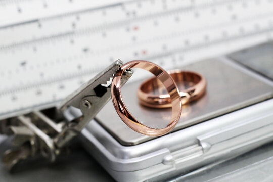 Two gold rings on tweezers, jewelry workshop, so close