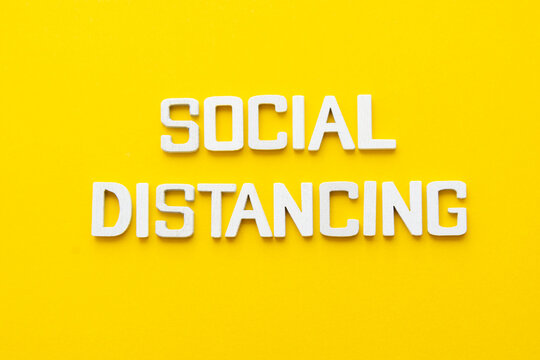 Social distancing word wooden letters yellow background. - Powered by Adobe