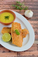 Fried salmon with potato puree garnish with lime and parsley