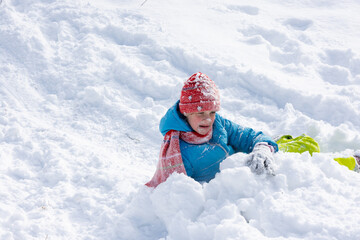 The girl who rolled down the hill has all her face and a hat in the snow