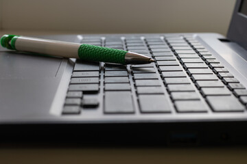Laptop keyboard black on gray background with a pen on it. Close-up of laptop keyboard.