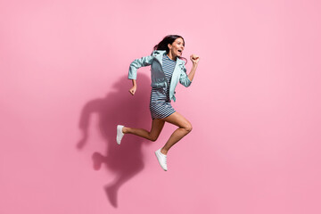 Full length photo of pretty adorable young girl dressed blue jacket hurrying running jumping isolated pink color background