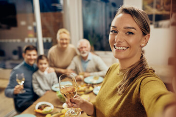 Happy family and her extended family taking selfie during lunch in dining room.