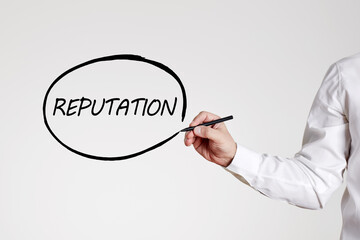 Businessman writes the word reputation with an outline circle on gray background. Business or...
