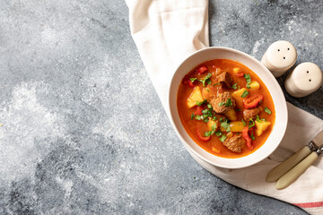 goulash is a traditional Hungarian dish with beef, potatoes, tomatoes and peppers. goulash in white...