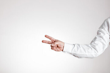 Businessman hand makes victory gesture on white background