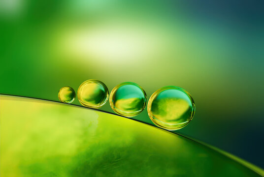 Abstract bright colorful background with drops of oil and water in green and yellow tones, macro. Creative image of the beauty of environment and nature.
