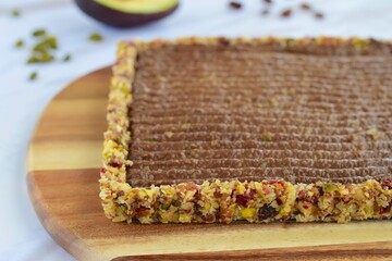 Chocolate avocado tart with pistachio date almond cranberry crust