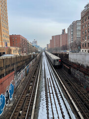 Fototapeta premium Manhattan, New York, USA. 2021. Subway train above ground leaving 125th station on snow covered tracks in the Morningside Heights district of Manhattan, NYC.