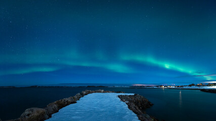 Fototapeta na wymiar Aurora Borealis on the night sky above the sea
