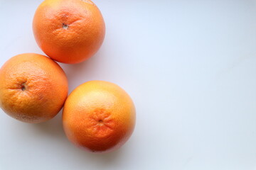 Three grapefruits on a white table 