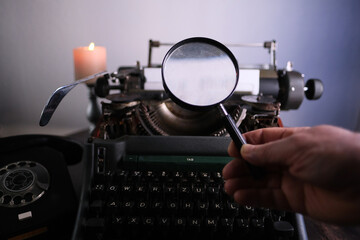 old typewriter on table, words true story are printed on paper in large size, retro style, magnifying glass, concept of writer, journalist, private detective