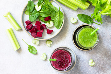 Vegan diet and nutrition, healthy detox, vegetarian concepts drinks. Beet smoothie and Green smoothie celery and spinach on a gray stone countertop. Top view flat lay.