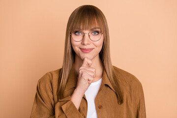 Photo of charming minded serious young woman hold hand chin think idea isolated on pastel beige...