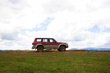 Offroad car on dirt rural road in mountain terrain