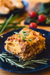 Piece of tasty hot lasagna with red wine. Selective focus