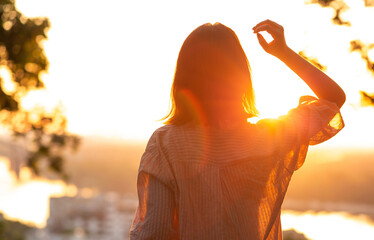 Young lady looking at sunset at the park