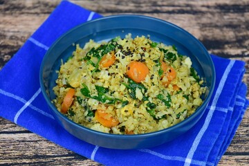 Organic Paleo Cauliflower Fried Rice with vegetables, Herbs and Spices. On wooden background