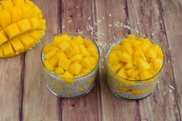 coconut mango chia seed pudding on wooden background
