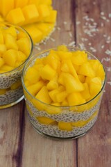 coconut mango chia seed pudding on wooden background
