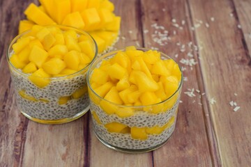 coconut mango chia seed pudding on wooden background
