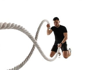 Ropes. Caucasian professional sportsman training isolated on white studio background. Muscular,...