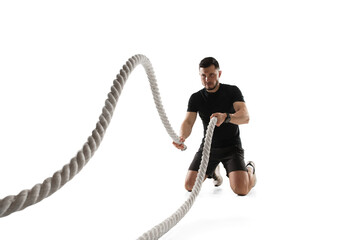 Ropes. Caucasian professional sportsman training isolated on white studio background. Muscular,...