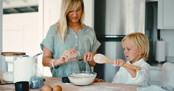 Loving happy mother and son baking cookies, playing with cookie dough in the kitchen, family home lifestyle
