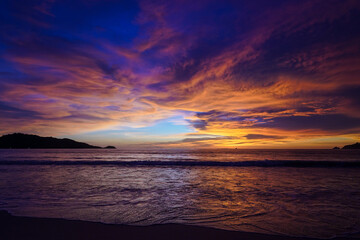 Bright scenic sunset on the beach in a blue orange shade