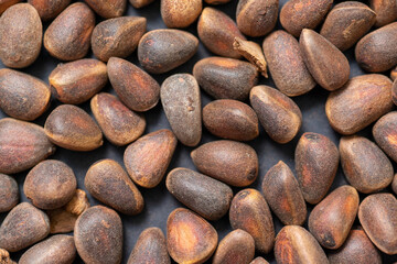 Background of pine nuts from Siberia close-up, you can see all the details of the shell.