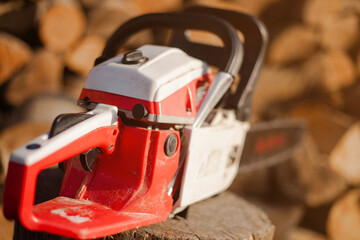 Chainsaw against the background of sawn trees. Woodworking industry. Logs of trees. 