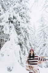 Young happy girl enjoys winter, frosty day, snow, on the background of a snow-covered landscape.The winter lifestyle.Individual winter adventures.Rest during the Christmas holidays.healthy break