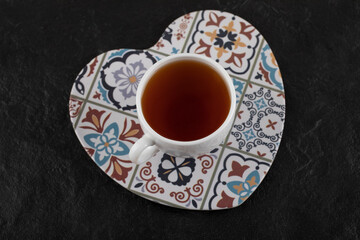 A white cup of hot tea on a beautiful plate