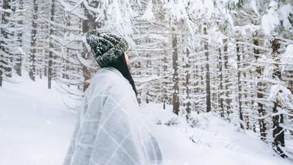 Young happy girl enjoys winter, frosty day, snow, on the background of a snow-covered landscape.The winter lifestyle.Individual winter adventures.Rest during the Christmas holidays.healthy break