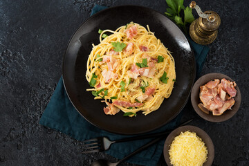 Pasta carbonara with bacon and parmesan on a plate, top view