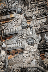 Fototapeta na wymiar Detail of a pagoda with statues of nats in Tharkhaung buddhist monastery in Burma, Myanmar