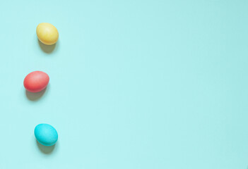 Colorful painted Easter eggs on the blue background. Top view. Copy space