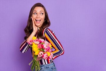 Photo portrait of girl keeping flowers bouquet looking copyspace amazed touching cheek isolated...