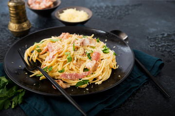 Spaghetti carbonara with bacon and parmesan on a plate, close-up