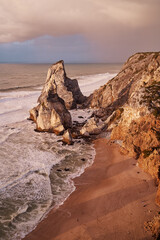 Obraz premium Portugal Ursa Beach at сoast of Atlantic Ocean. Rocks and waves at sand of coastline picturesque landscape.