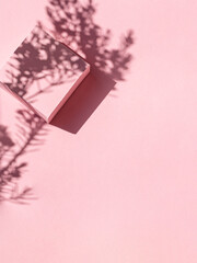 Minimalistic pink background with geometric shapes and shadows from tree. Copy space.