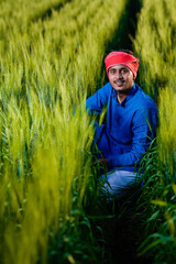 Naklejka na ściany i meble Young indian farmer at wheat field and giving happy expression