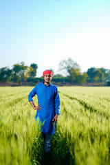 Naklejka na ściany i meble Young indian farmer at green wheat field