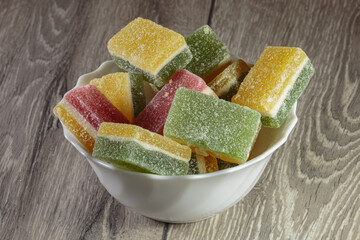 Multi colored layered marmalade in a dish. Closeup of wonderful dessert.