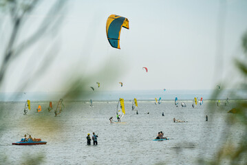 People swim in the sea on a kiteboard or kitesurfing. Summer sport learning how to kitesurf. Kite surfing on Puck bay in Jastarnia, Poland