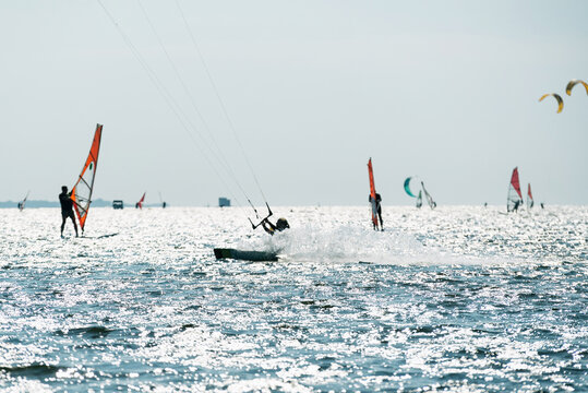 People swim in the sea on a kiteboard or kitesurfing. Summer sport learning how to kitesurf. Kite surfing on Puck bay in Jastarnia, Poland