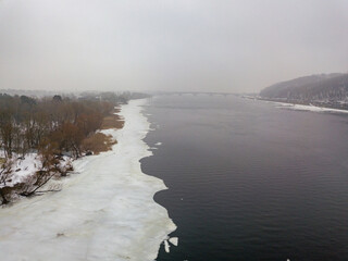 Ice edge on the river. Aerial drone view. Winter foggy morning.