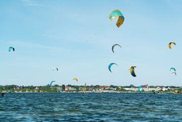 People swim in the sea on a kiteboard or kitesurfing. Summer sport learning how to kitesurf. Kite surfing on Puck bay in Jastarnia, Poland