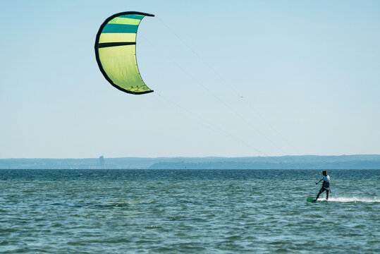 People swim in the sea on a kiteboard or kitesurfing. Summer sport learning how to kitesurf. Kite surfing on Puck bay in Jastarnia, Poland
